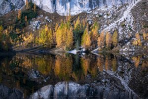 A wonderful still lake in the morning light during peak autumn, Dolomites