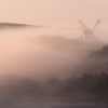 A thick mist wraps the landscape in Sussex, while an age old windmill peers out above the layers
