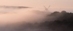 A thick mist wraps the landscape in Sussex, while an age old windmill peers out above the layers