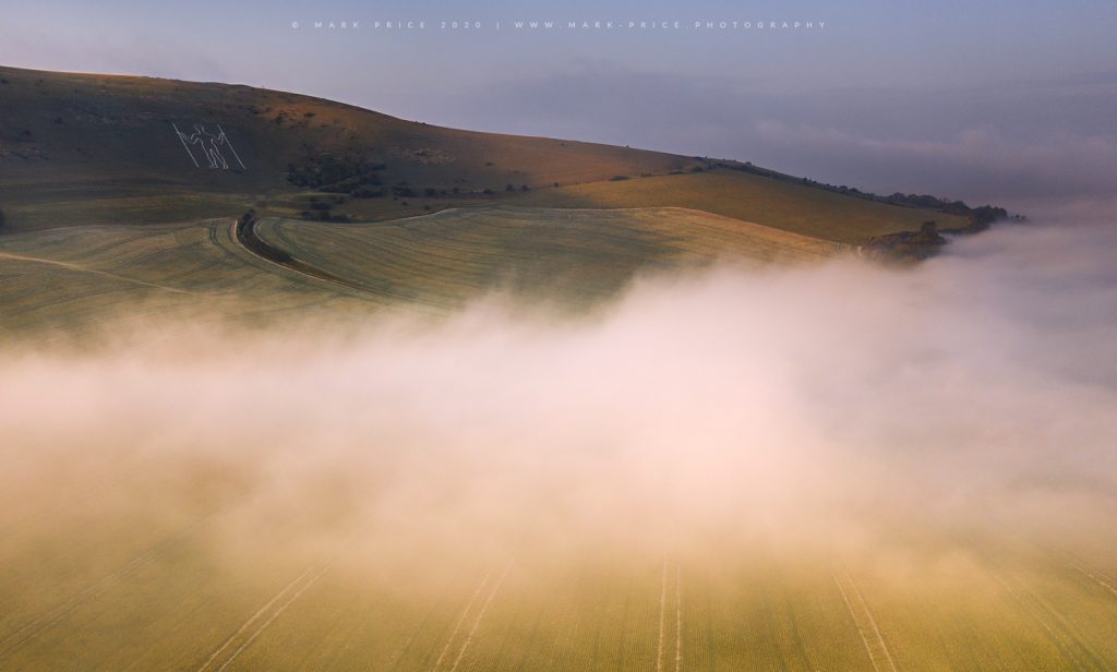 The historic Long Man of Wilmington stands over the rolling mist of an Autumn in Sussex