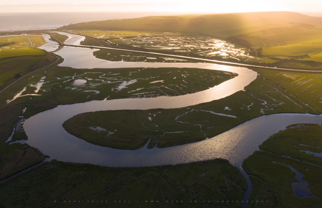 Sun sets on the fascinating meandering sea estuary at Cuckmere Haven, Sussex