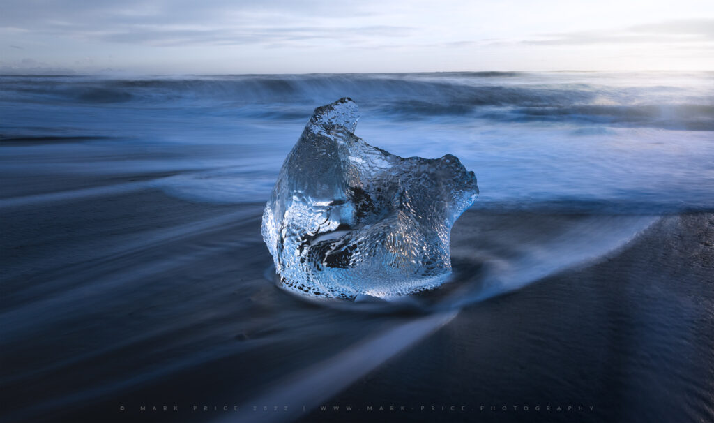 A beautiful piece of ice from the Vatnajokull Glacier shines on the shore.