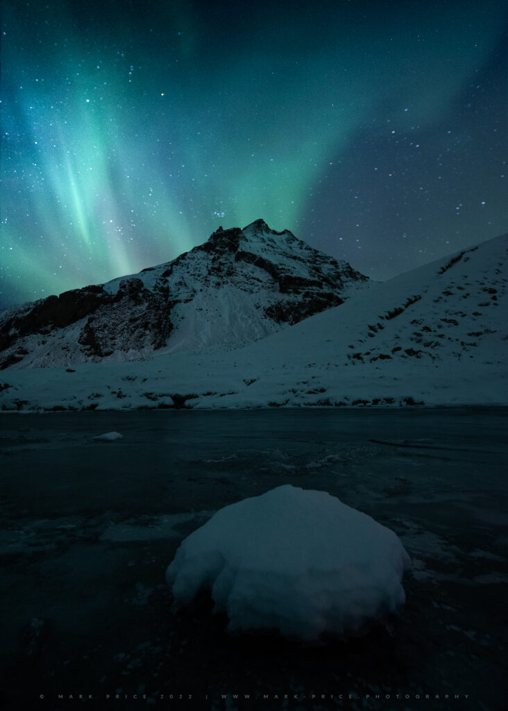 Northern lights provide a nocturnal backdrop to this river scene.