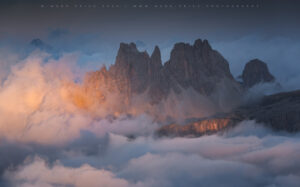 Glorious sunlight hitting the huge mountains of the Dolomites during a cloud inversion, summer 2022