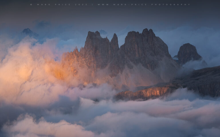 Glorious sunlight hitting the huge mountains of the Dolomites during a cloud inversion, summer 2022