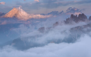 Towering Peaks emerge above the clouds in the Dolomites.